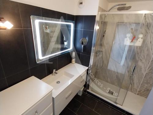 une salle de bain avec une douche, un lavabo et un miroir dans l'établissement quartier des plages spacieux appartement 1 chambre avec parking, à Sète