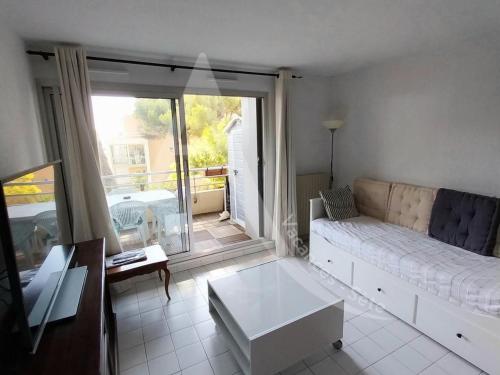 un salon avec un canapé et une grande fenêtre dans l'établissement quartier des plages spacieux appartement 1 chambre avec parking, à Sète