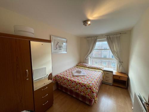 een kleine slaapkamer met een bed en een raam bij Workers 3 bedroom beach boulevard apt in Aberdeen