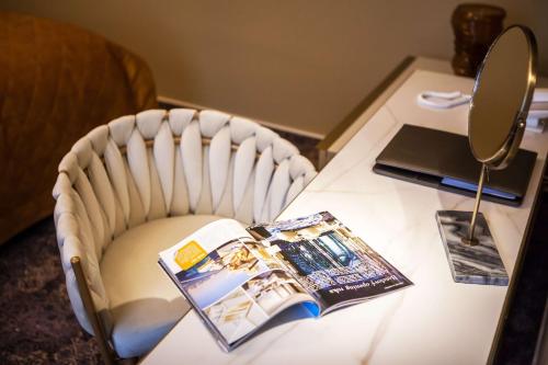 a desk with a chair with a mirror and a book on it at Mestský Hotel Ďumbier in Brezno