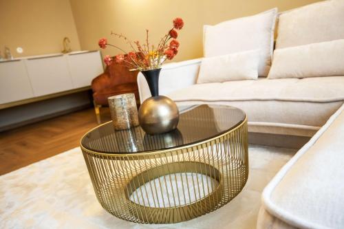a living room with a gold coffee table and a couch at Mestský Hotel Ďumbier in Brezno