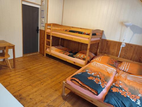 a bedroom with two bunk beds and a table at Vila Slunečnice in Vejprty