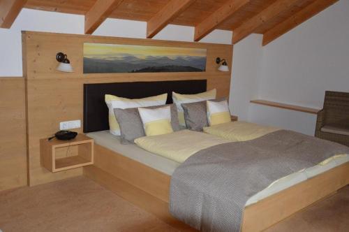 a bedroom with a large bed with a wooden headboard at FrongaHOF in Waldkirchen