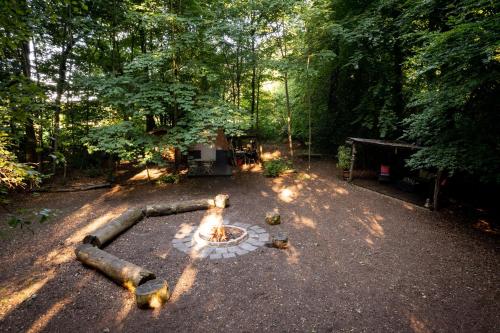 a fire pit in the middle of a yard with trees at Hollington Park Glamping in Newbury