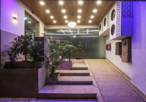 a hallway with stairs and potted plants in a building at Hotel Emerald Suites & Banquet By Aura in Noida