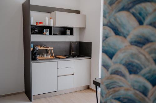 a kitchen with white cabinets and a mural at DimorAmare in Bari