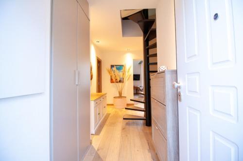 un couloir avec une porte blanche et une cuisine avec un escalier dans l'établissement Stylish & Spacious 2-Bed Duplex in Cannes, à Cannes