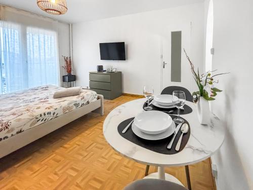 ein Schlafzimmer mit einem Bett und einem Tisch mit Tellern darauf in der Unterkunft Cozy Balcon près de la Marne in Saint-Maur-des-Fossés