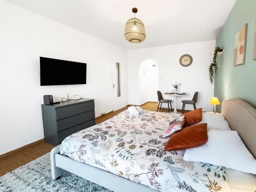 ein Schlafzimmer mit einem Bett, einem Fernseher und einem Tisch in der Unterkunft Cozy Balcon près de la Marne in Saint-Maur-des-Fossés