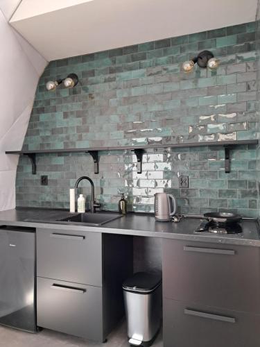 a kitchen with a sink and a brick wall at Glamping Liptov in Liptovský Trnovec