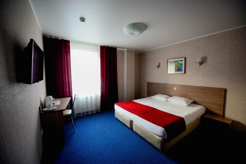 Habitación de hotel con cama y ventana en Aron Hotel, en Kazán