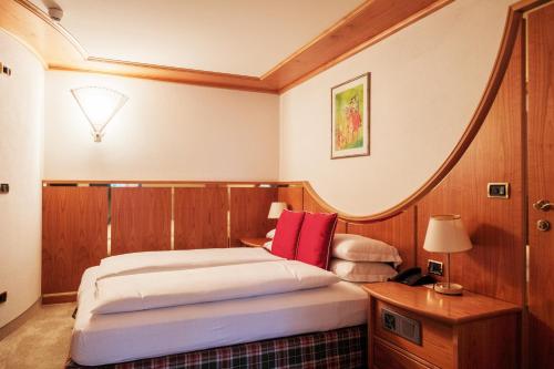 a bedroom with a bed with a round headboard at Sporthotel Teresa in Badia