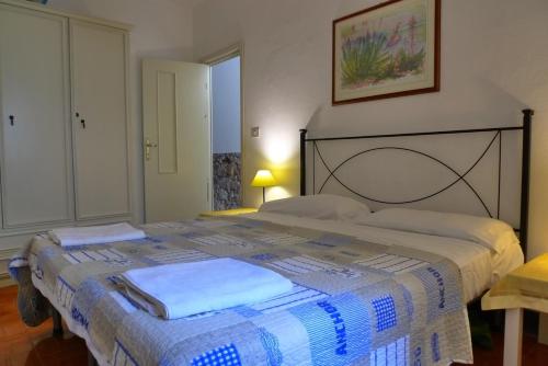 a bedroom with a bed with a blue and white blanket at Casa Vista Mare in Bosa