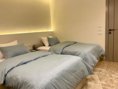 a bedroom with two beds and a couch at Zahir 801 in Cairo