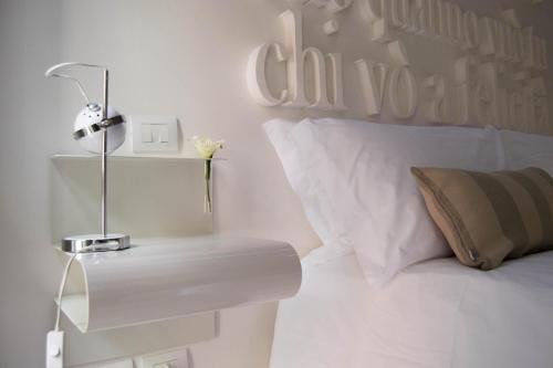 a white bedroom with a bed with a white headboard at Hotel Santa Brigida in Naples
