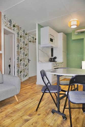 une cuisine et un salon avec une table et des chaises dans l'établissement Le FOCH, appartement 3 chambres - proche Nancy Thermal, à Villers-lès-Nancy