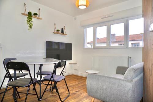 una sala de estar con una mesa, sillas y un sofá en Le FOCH, appartement 3 chambres - proche Nancy Thermal, en Villers-lès-Nancy