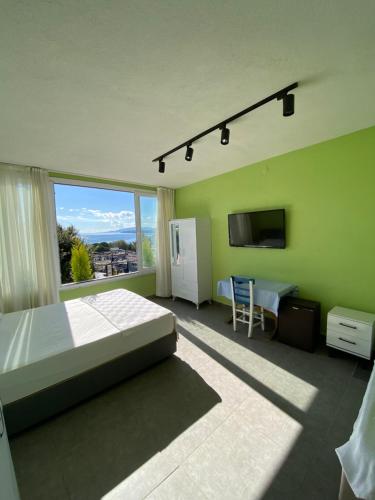 a bedroom with a bed and a large window at Sıla pansiyon in Gümbet