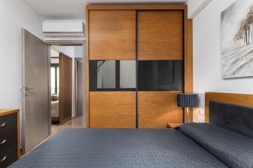 a bedroom with a bed and a large wooden closet at Icon of the seas Sithonia in Neos Marmaras