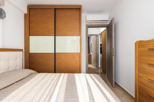 a bedroom with a bed and a wooden door at Icon of the seas Sithonia in Neos Marmaras
