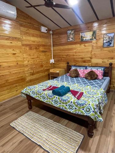 a bedroom with a bed with two teddy bears on it at WOODMOOD Cottages in Chapora