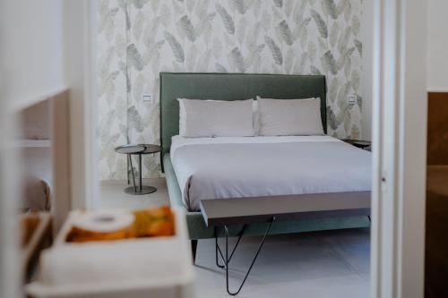 a bedroom with a bed with a green headboard at DimorAmare in Bari