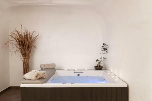 a bath tub in a white room with a blue bathtub at Elisabeth Boutique Hotel in Thessaloniki