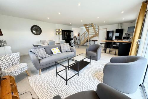 un salon avec un canapé, des chaises et une table dans l'établissement Maison contemporaine tout confort -5min des plages, à Kervignac