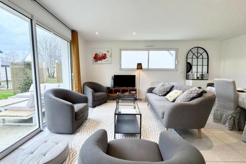 un salon avec deux canapés et une télévision dans l'établissement Maison contemporaine tout confort -5min des plages, à Kervignac