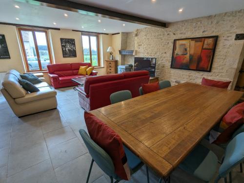 un salon avec une table et des chaises en bois dans l'établissement Retraite au bord de la rivière, à Morlac
