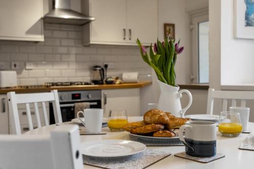 a kitchen with a table with a plate of pastries at Exeter Station House - Short Stays UK Ltd in Exeter