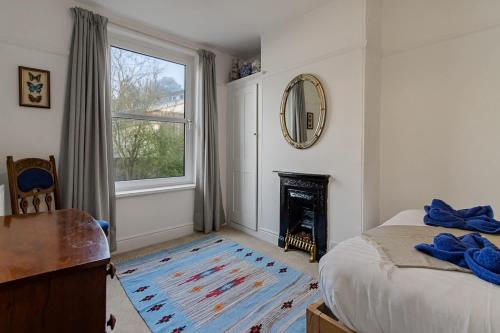 a bedroom with a bed and a mirror and a fireplace at Exeter Station House - Short Stays UK Ltd in Exeter