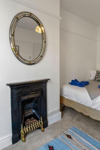 a mirror over a fireplace in a room with a bed at Exeter Station House - Short Stays UK Ltd in Exeter