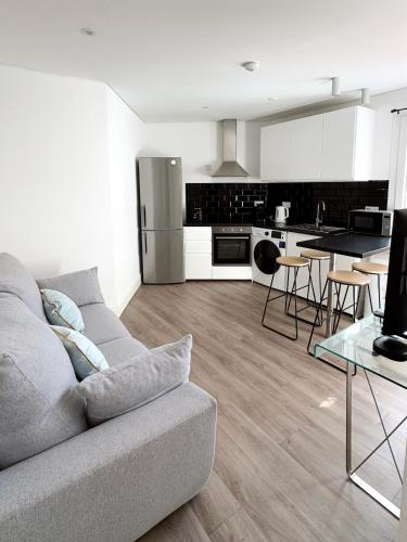 a living room with a couch and a kitchen at Modern City Centre Two Bedroom Windsor Apartment - Grand Central House in Gibraltar