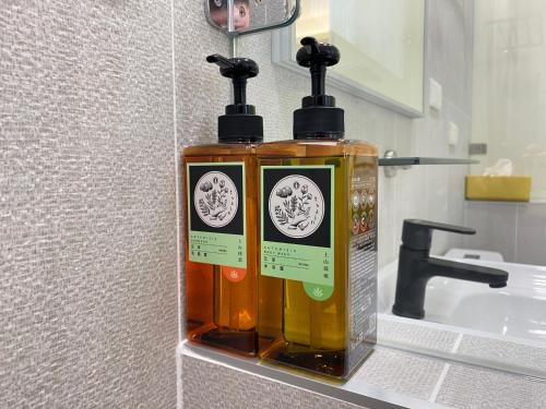 two bottles of soap sitting on a bathroom sink at Ashore 196 B&B in Dongshan