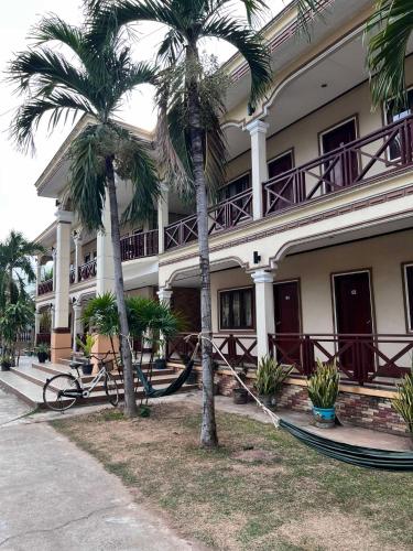 two palm trees in front of a building at Lebijou Guesthouse - Konesavath in Don Det