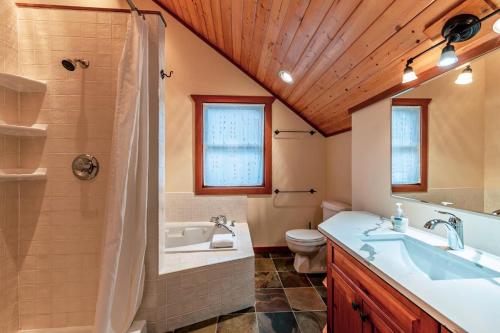 a bathroom with a sink and a shower and a toilet at GrizzPaw Lodge - Mountain Resort - 5 Bedroom Chalet - Sleeps 14 People in Golden
