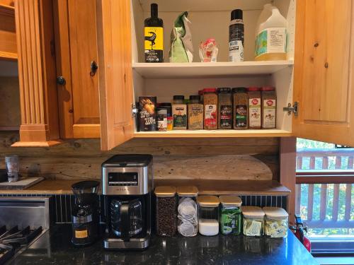 a kitchen counter with a coffee maker and spices at GrizzPaw Lodge - Mountain Resort - 5 Bedroom Chalet - Sleeps 14 People in Golden