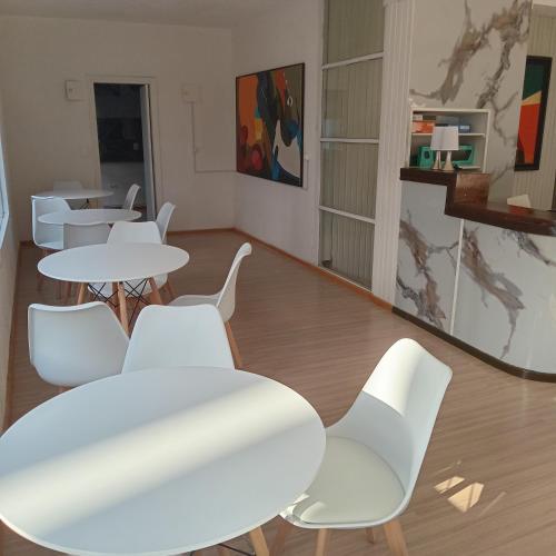 Hotel RICHMOND Punta del Este في بونتا دل إستي: غرفة بطاولات بيضاء وكراسي بيضاء