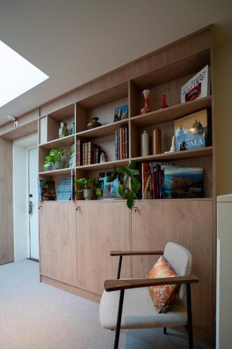 a room with a book shelf with a chair and a table at CENTRAL Hostel Lille Centre in Lille