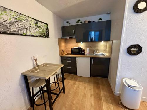 une petite cuisine avec une petite table et un évier dans l'établissement Studio en plein centre ville, à Nogent-sur-Marne