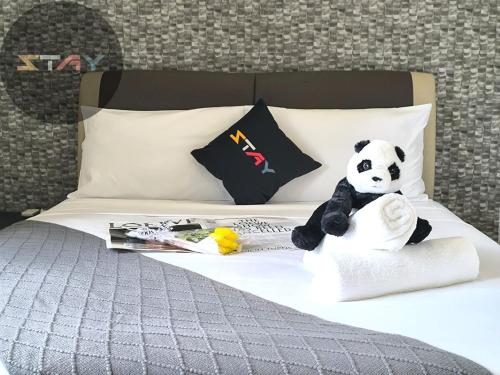 a stuffed panda bear sitting on top of a bed at D'Pristine 6Pax Tranquil Lakeview Netflix By STAY in Iskandar Puteri