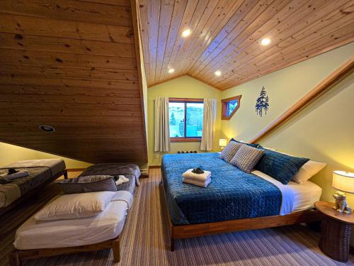 a bedroom with a bed in a room with wooden ceilings at GrizzPaw Lodge - Mountain Resort - 5 Bedroom Chalet - Sleeps 14 People in Golden