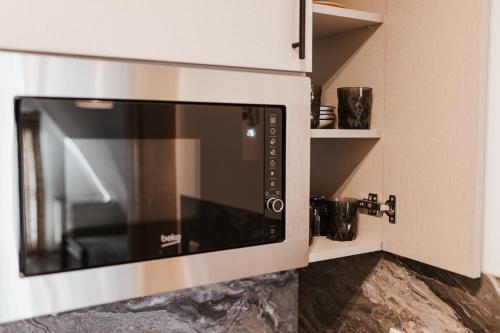 a microwave oven in the corner of a kitchen at Dom Wypocz Pod Litwinką Apartamenty in Białka Tatrzanska