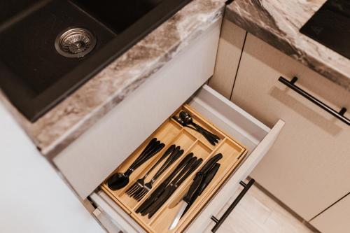 a kitchen counter with a cutting board with utensils at Dom Wypocz Pod Litwinką Apartamenty in Białka Tatrzanska
