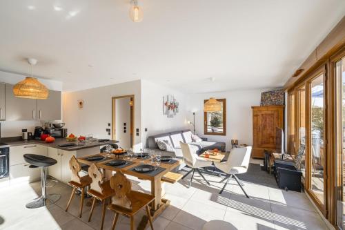 une cuisine et un salon avec une table et des chaises dans l'établissement Serre-Chevalier T4 luxe pied pistes, au Monêtier-les-Bains