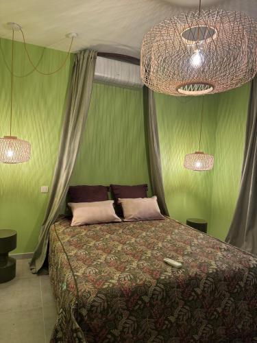 a bedroom with a bed with a green wall at Appartement 2 personnes - Storia in Stockay