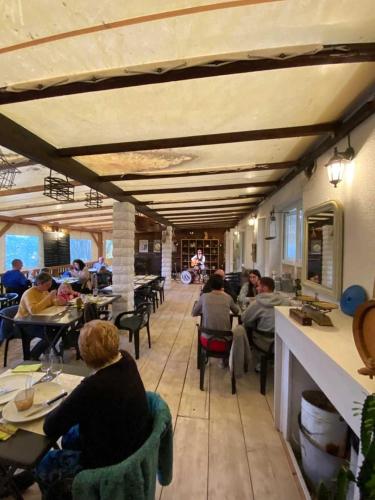 un groupe de personnes assises à des tables dans un restaurant dans l'établissement Camping 4 étoiles - Piscine - efcfbi, à Faverolles-sur-Cher