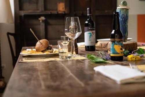 a table with wine bottles and a plate of food at Tenuta di Paganico - I Roggeti in Paganico