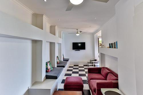 a hallway with red chairs and a tv on a wall at La Pirogue 1 in Westbrook